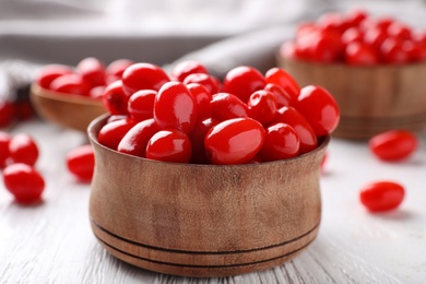 Fresh ripe goji berries in bowl on white wooden table