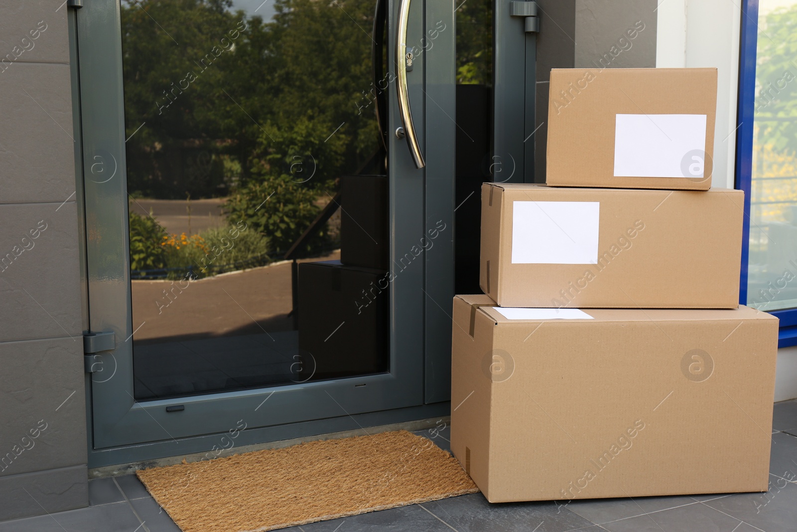 Photo of Cardboard boxes near door. Parcel delivery service