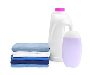 Photo of Stack of baby clothes and laundry detergents isolated on white