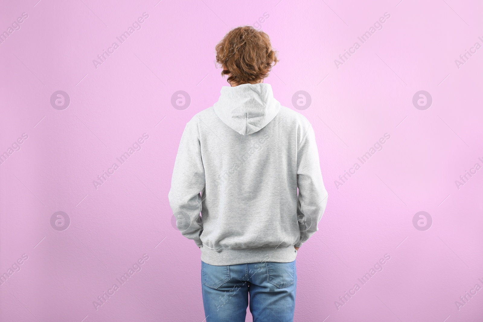 Photo of Man in hoodie sweater on color background. Space for design