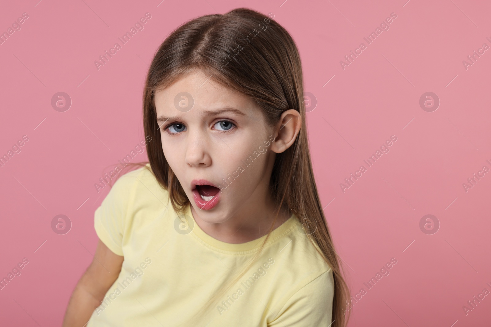 Photo of Portrait of surprised girl on pink background