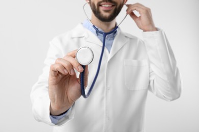 Photo of Doctor with stethoscope on white background, closeup. Cardiology concept