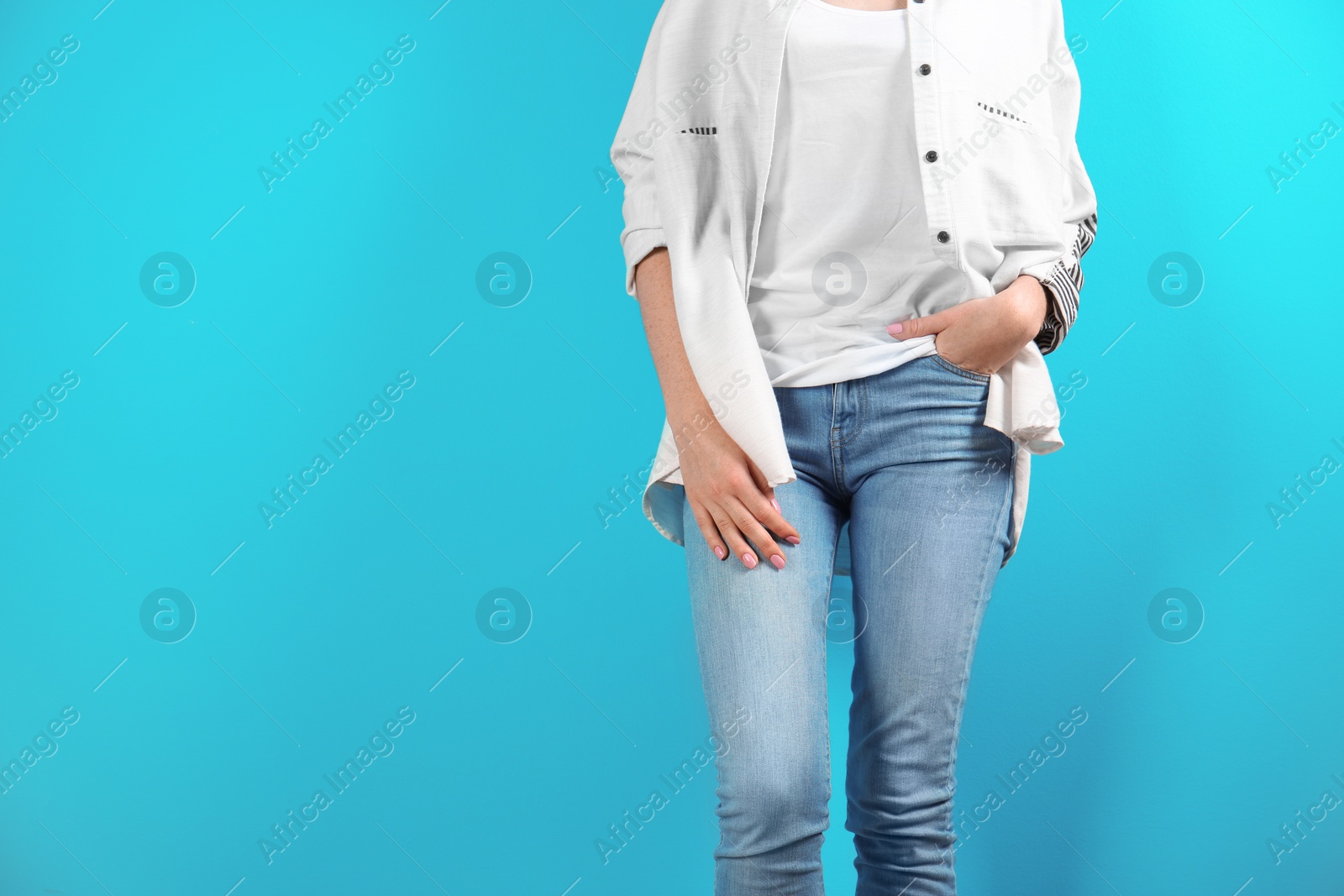 Photo of Young woman in stylish jeans on color background