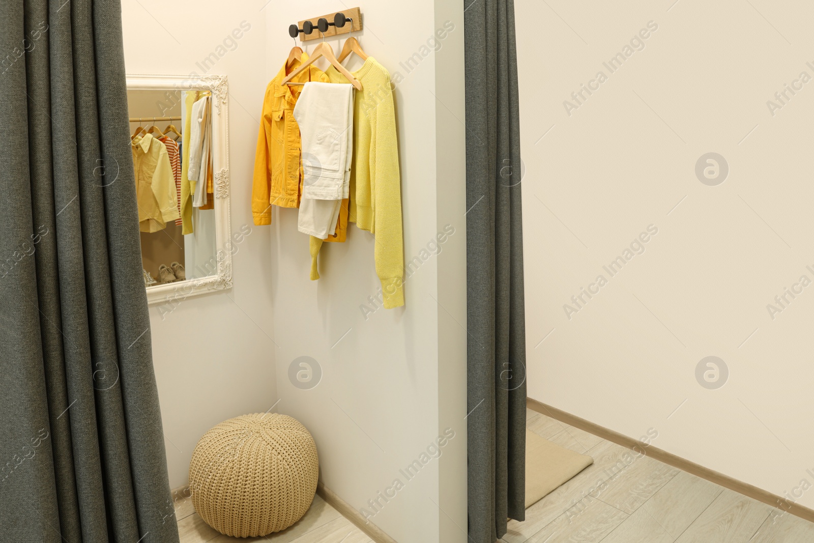 Photo of Dressing room with mirror in fashion store. Stylish design