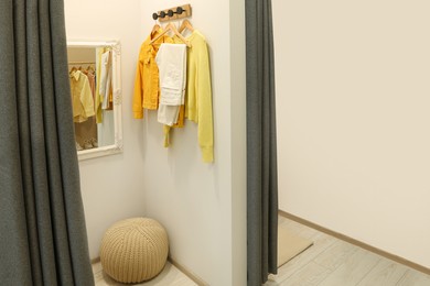 Photo of Dressing room with mirror in fashion store. Stylish design