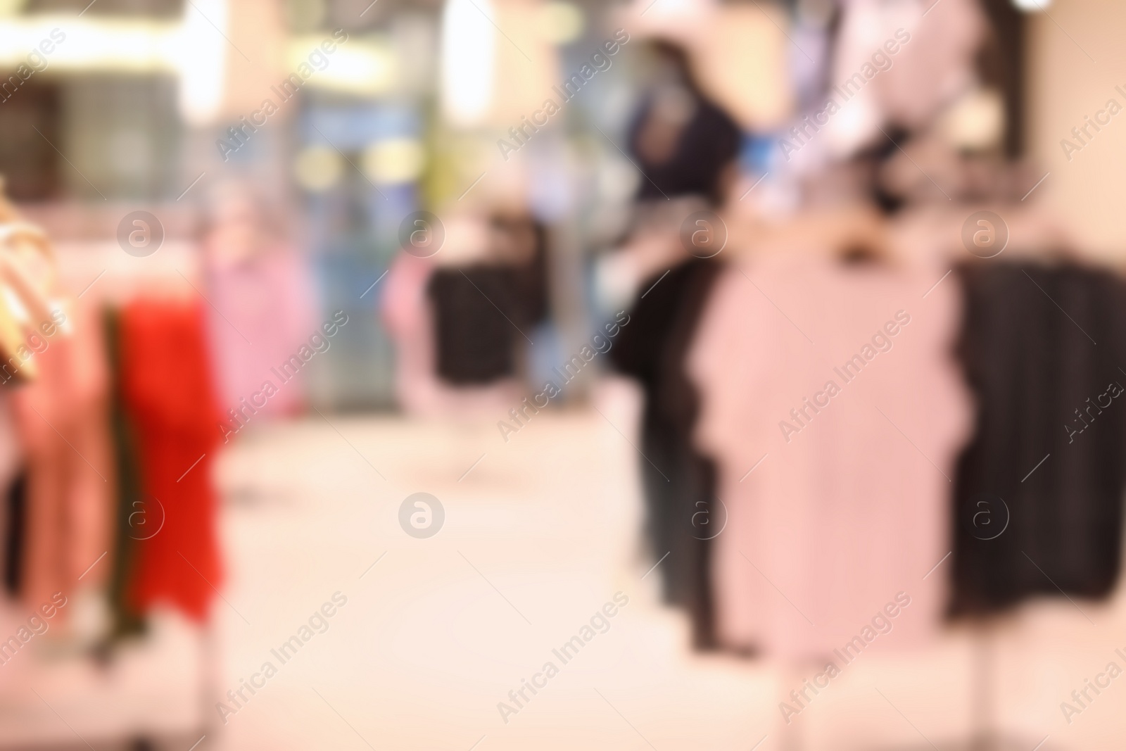 Photo of Blurred view of modern store with different clothes