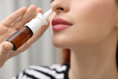 Photo of Medical drops. Woman using nasal spray at home, closeup