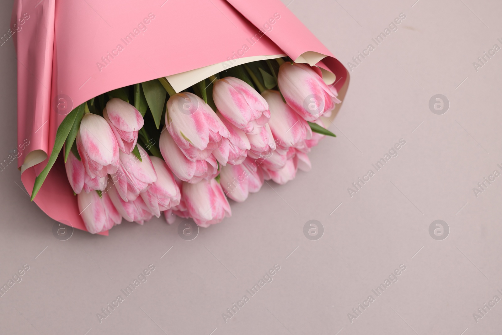 Photo of Beautiful bouquet of fresh pink tulips on light background. Space for text