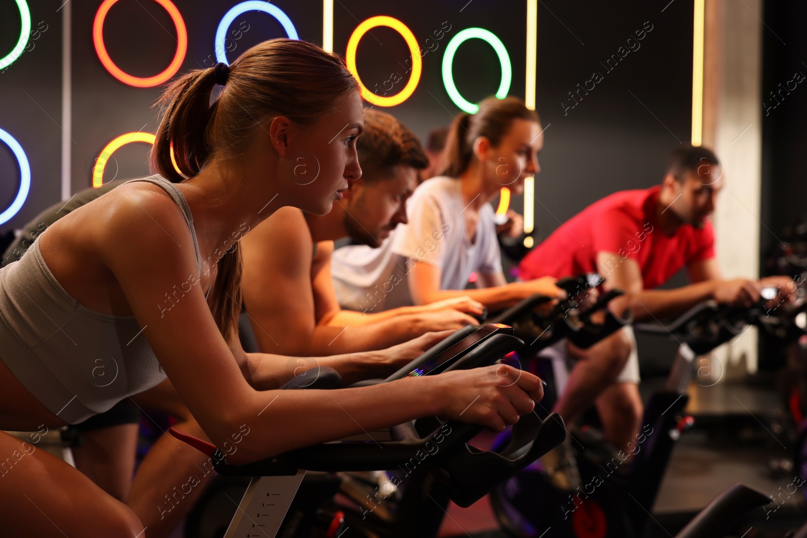 Photo of Group of people training on exercise bikes in fitness club