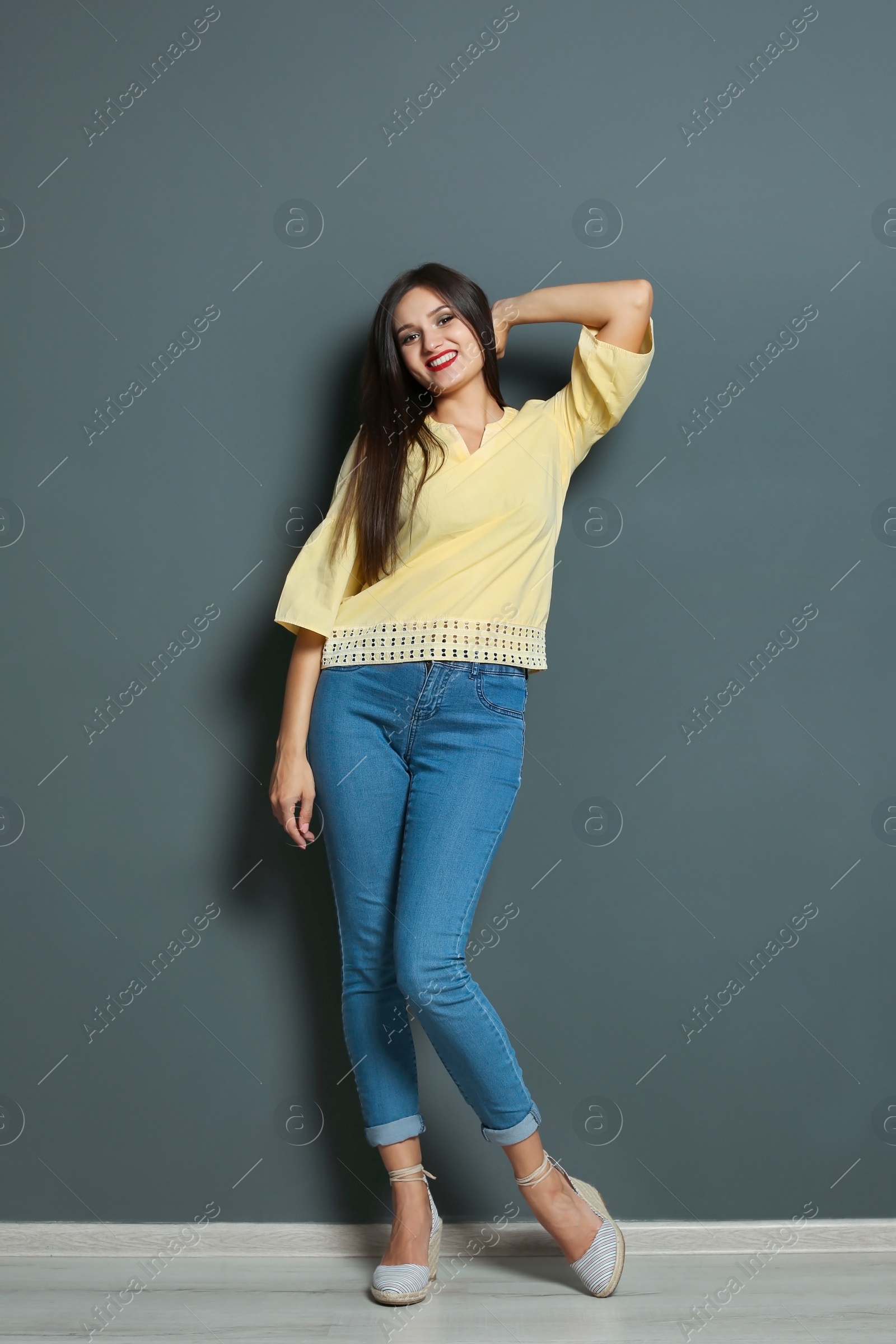 Photo of Full length portrait of beautiful woman with sexy legs near grey wall