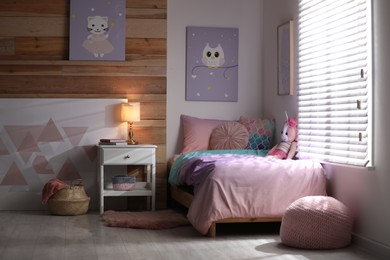 Bed with beautiful linens in children's room. Modern interior design