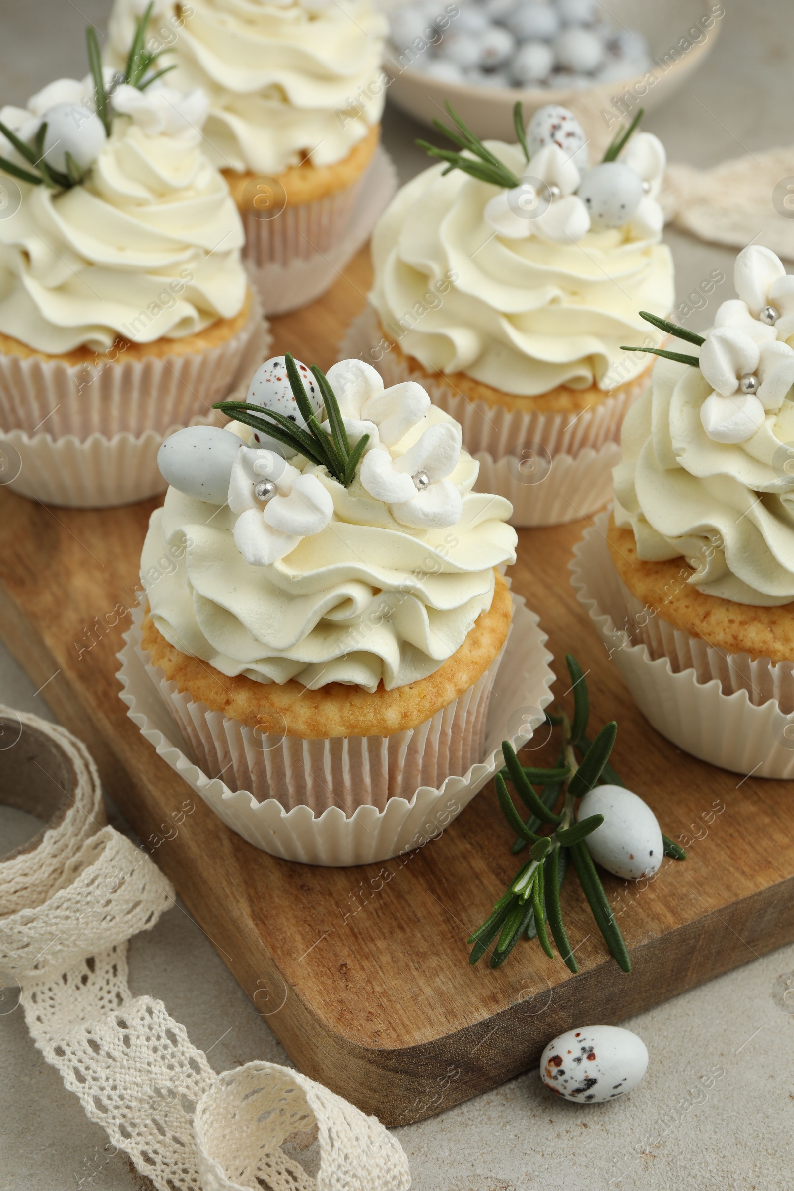 Photo of Tasty Easter cupcakes with vanilla cream on table, closeup