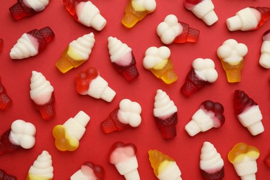 Tasty jelly candies in shape of ice cream on red background, flat lay