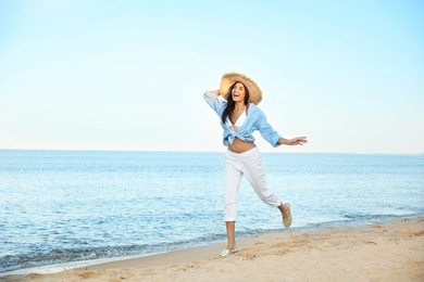 Photo of Beautiful young woman in straw hat on beach