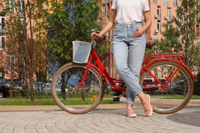 Young woman near modern color bicycle outside, closeup