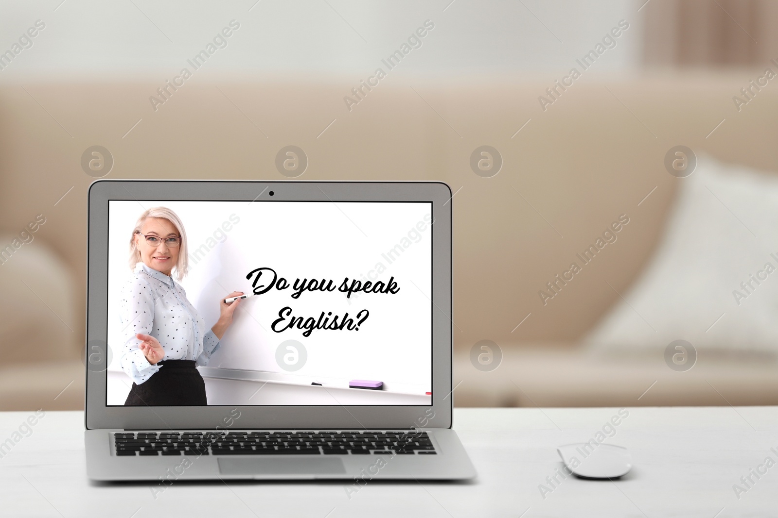 Image of Modern laptop for online English learning with teacher on table indoors