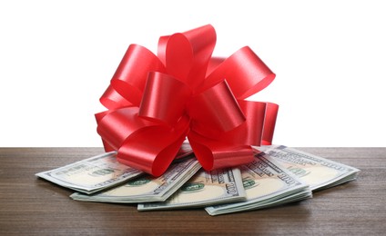 Photo of Dollar bills with red bow on wooden table against white background