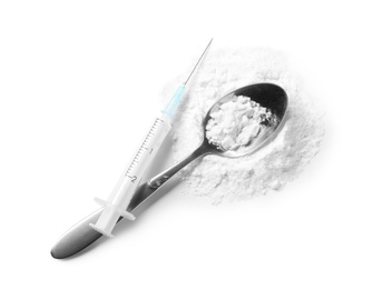 Photo of Spoon with cocaine and empty syringe on white background, top view