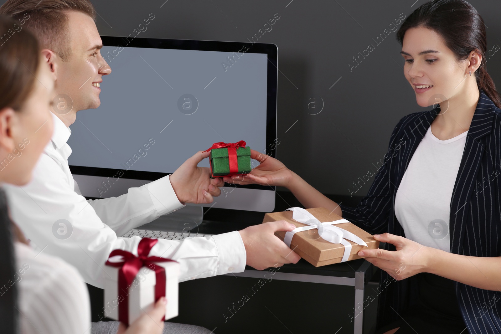 Photo of Colleagues presenting gifts each other in office