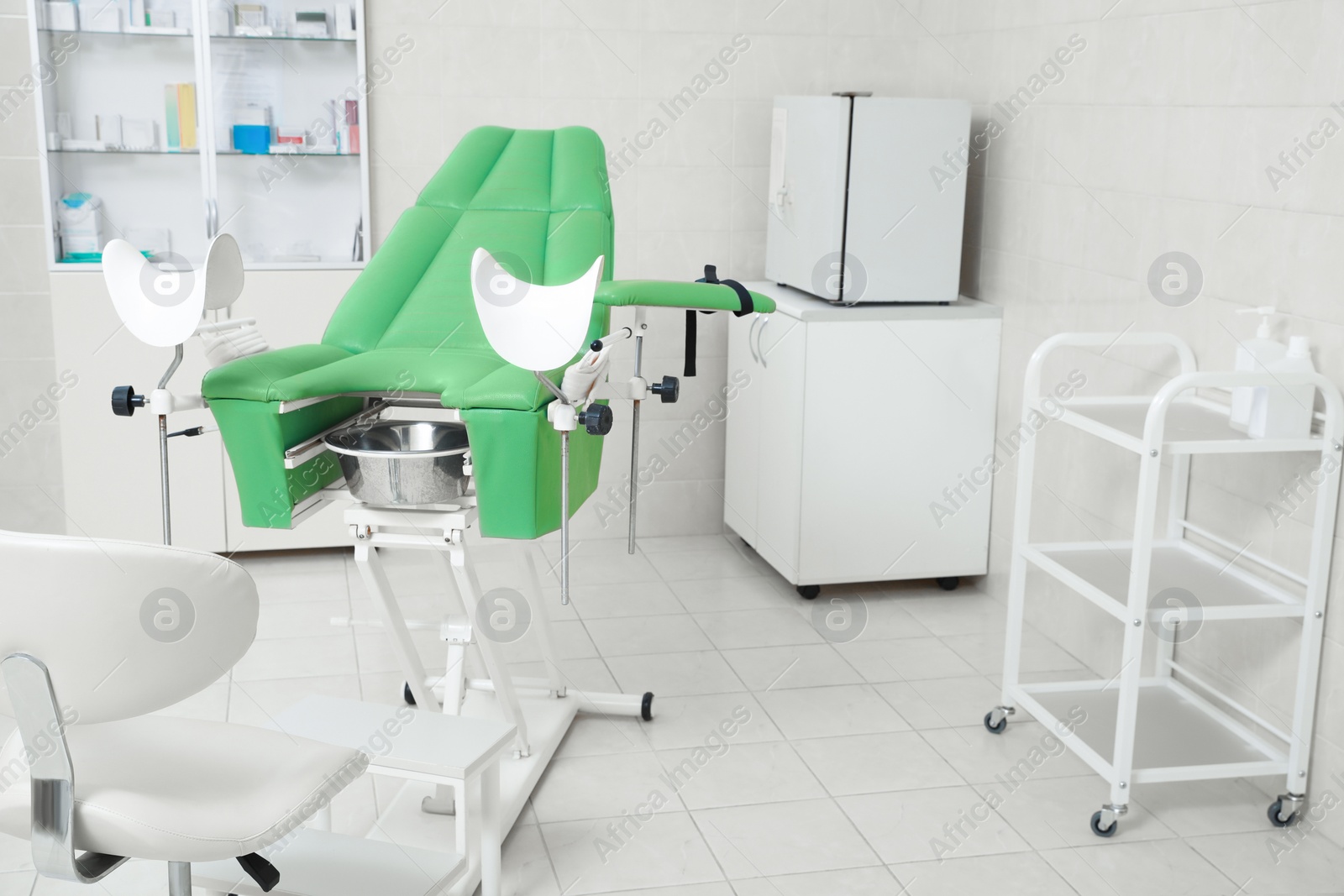 Photo of Modern gynecological office interior with examination chair and medical equipment