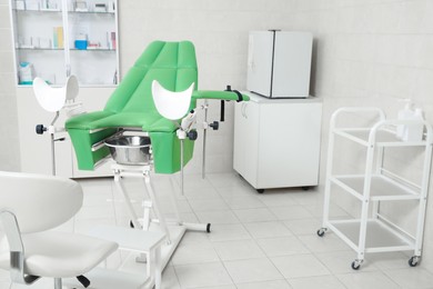 Photo of Modern gynecological office interior with examination chair and medical equipment