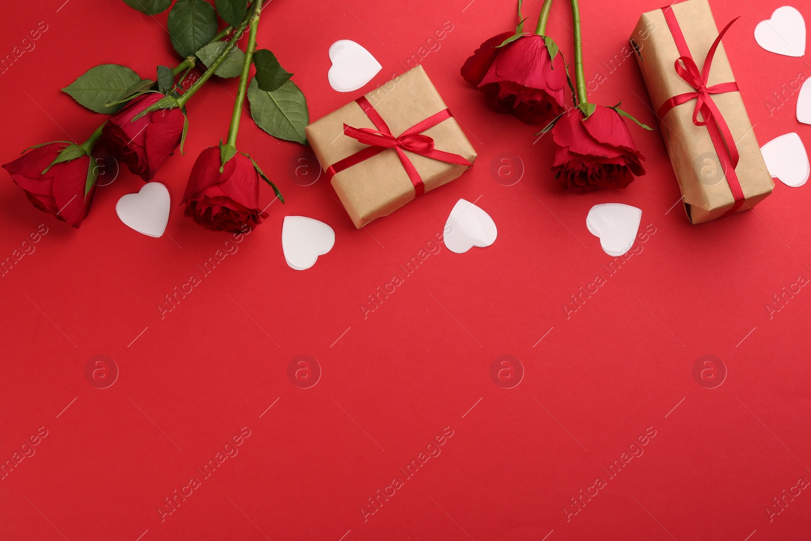 Photo of Beautiful gift boxes, hearts and roses on red background, flat lay with space for text. Valentine's day celebration