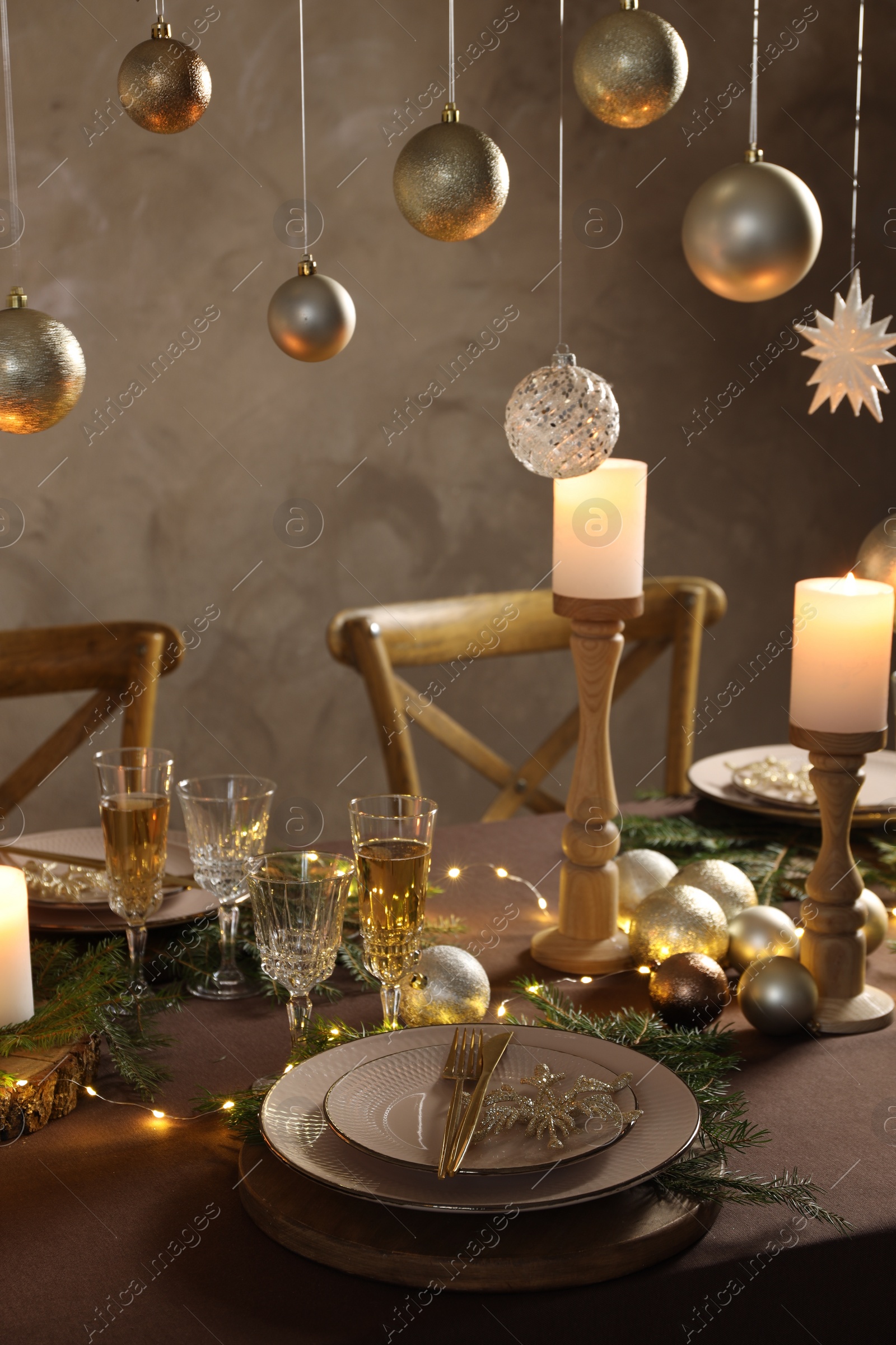 Photo of Christmas table setting with burning candles and festive decor