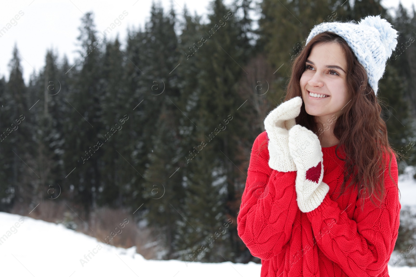 Photo of Happy young woman in warm clothes outdoors, space for text. Winter vacation