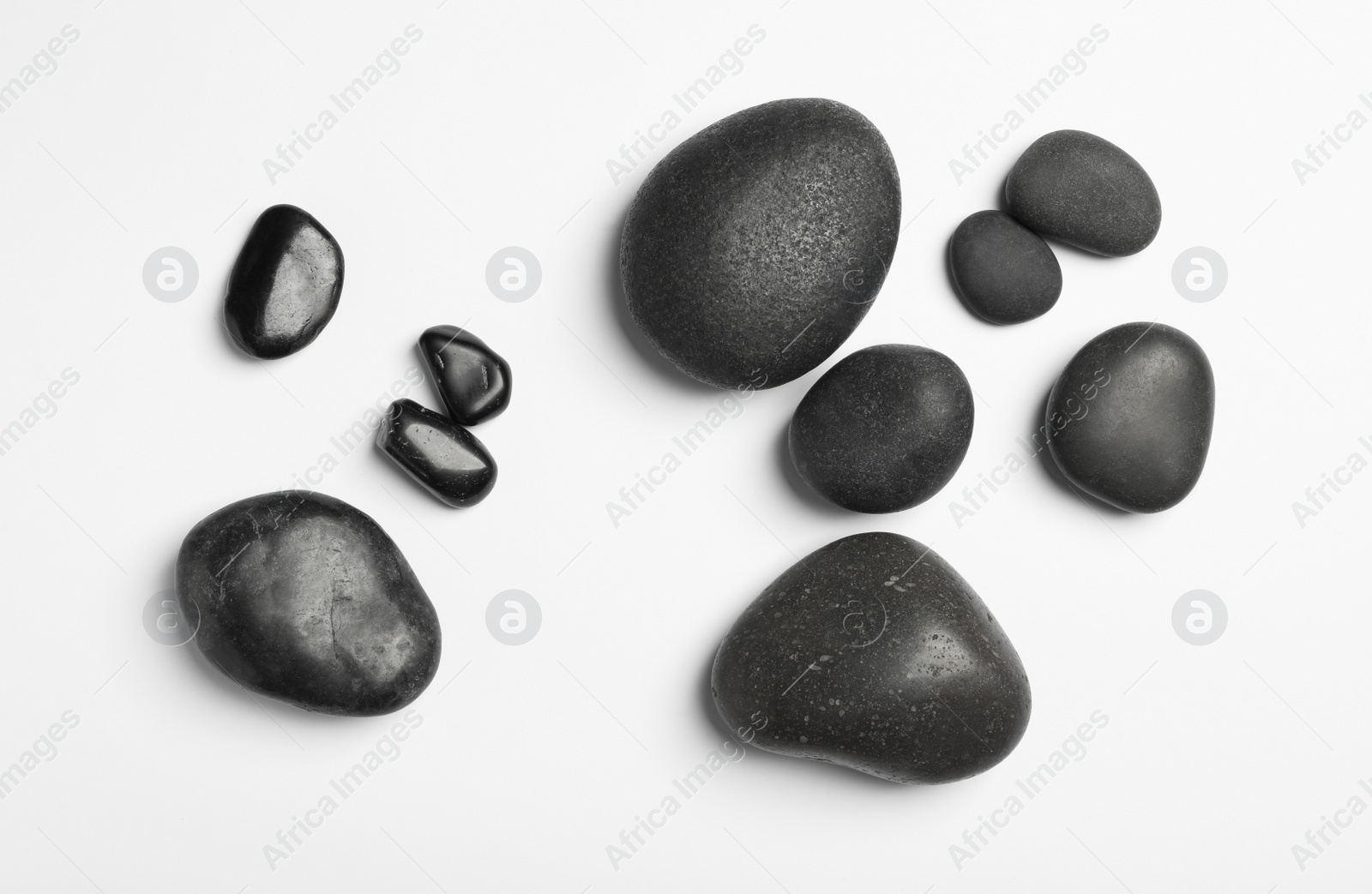 Photo of Many different stones on white background, top view