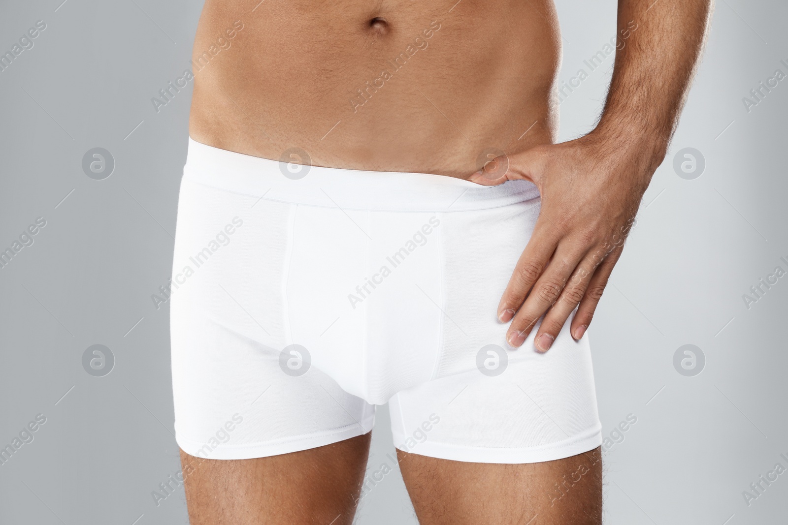 Photo of Man in white underwear on light grey background, closeup