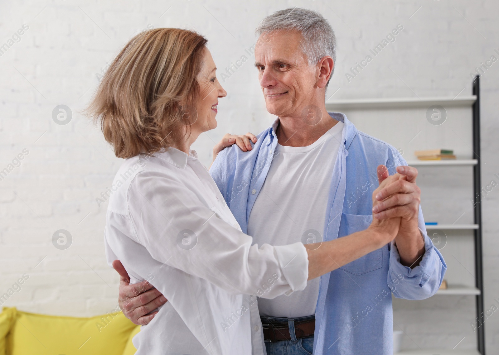 Photo of Happy senior couple dancing together in living room