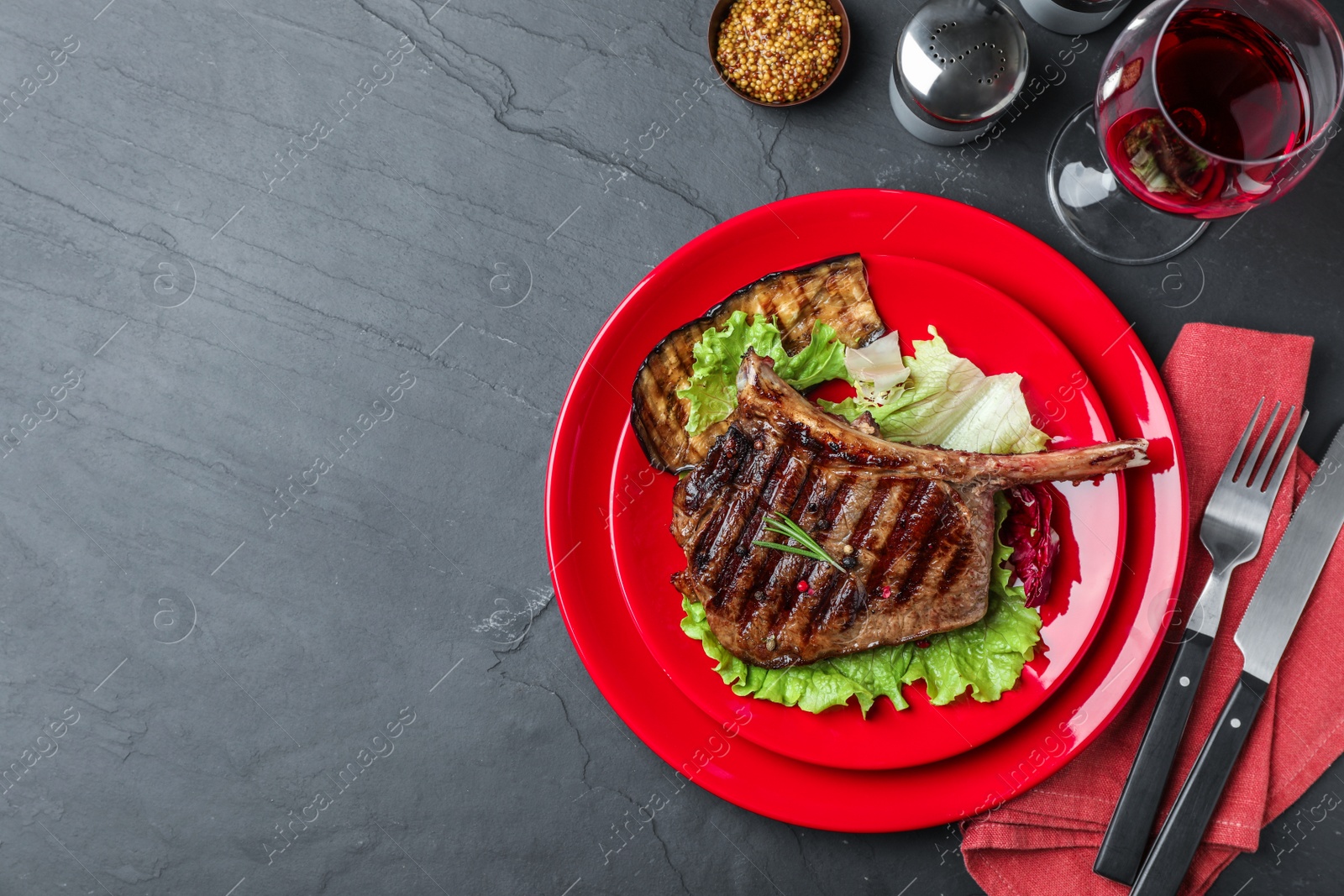 Photo of Delicious beef steak served on grey table, flat lay. Space for text