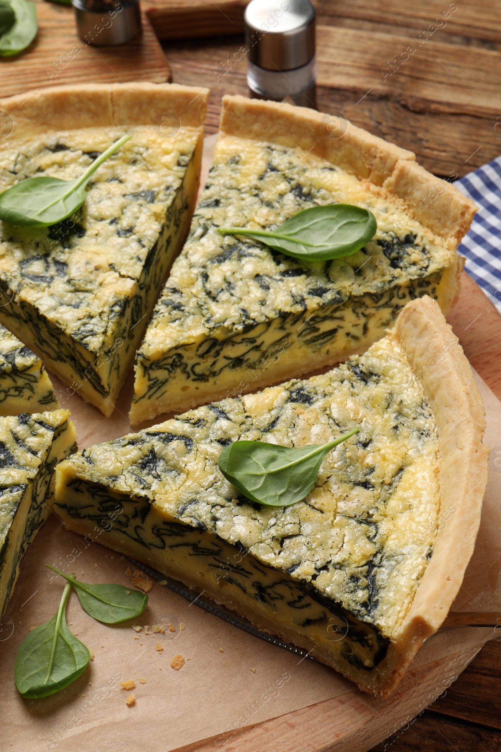 Photo of Cut delicious spinach pie on wooden board
