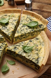 Cut delicious spinach pie on wooden board