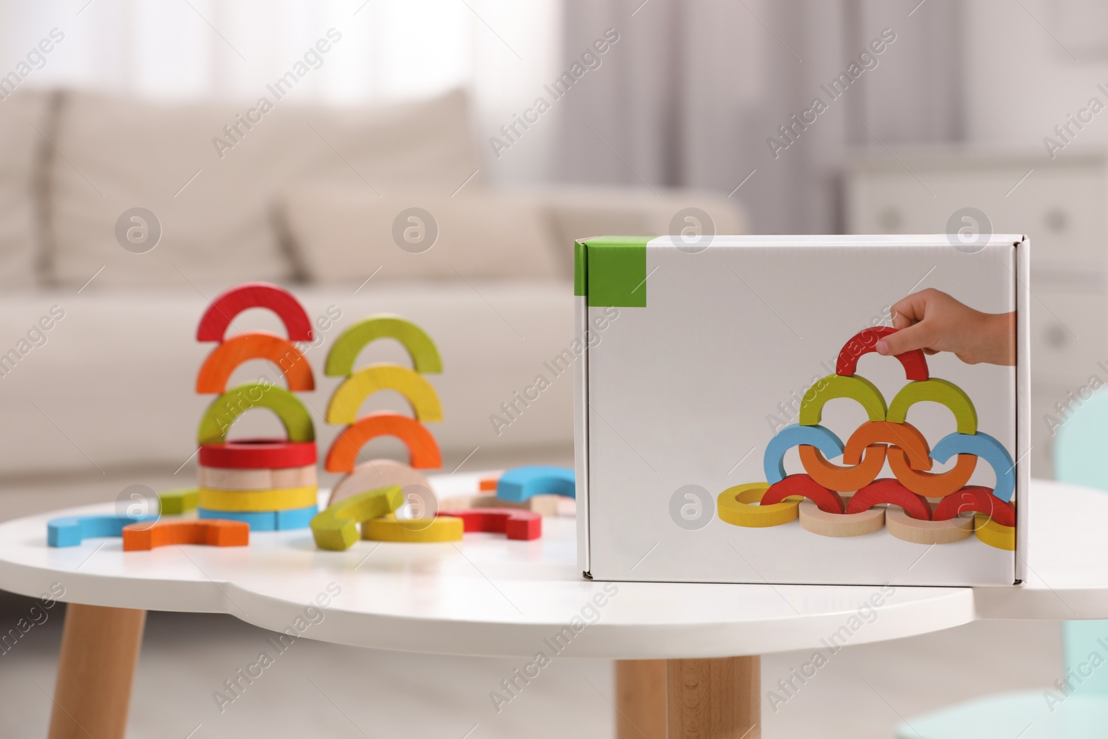 Photo of Colorful wooden pieces of playing set on white table indoors. Educational toy for motor skills development