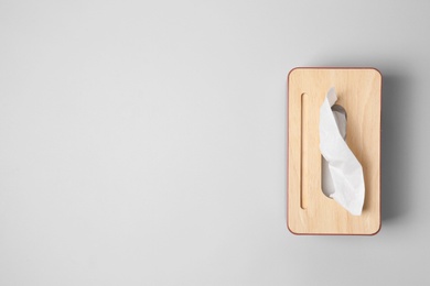 Photo of Holder with paper tissues on light grey background, top view. Space for text