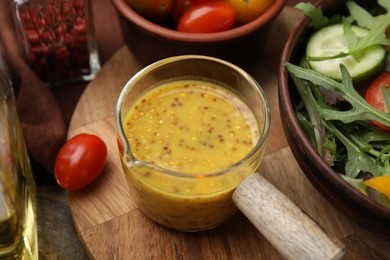 Tasty vinegar based sauce (Vinaigrette), salad and tomatoes on wooden table, closeup