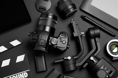 Photo of Flat lay composition with camera and video production equipment on black background