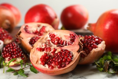 Photo of Delicious ripe pomegranates on white table, closeup