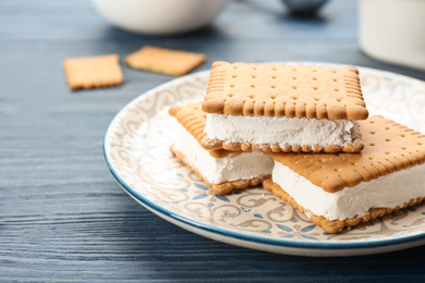 Sweet delicious ice cream cookie sandwiches on blue wooden table, closeup