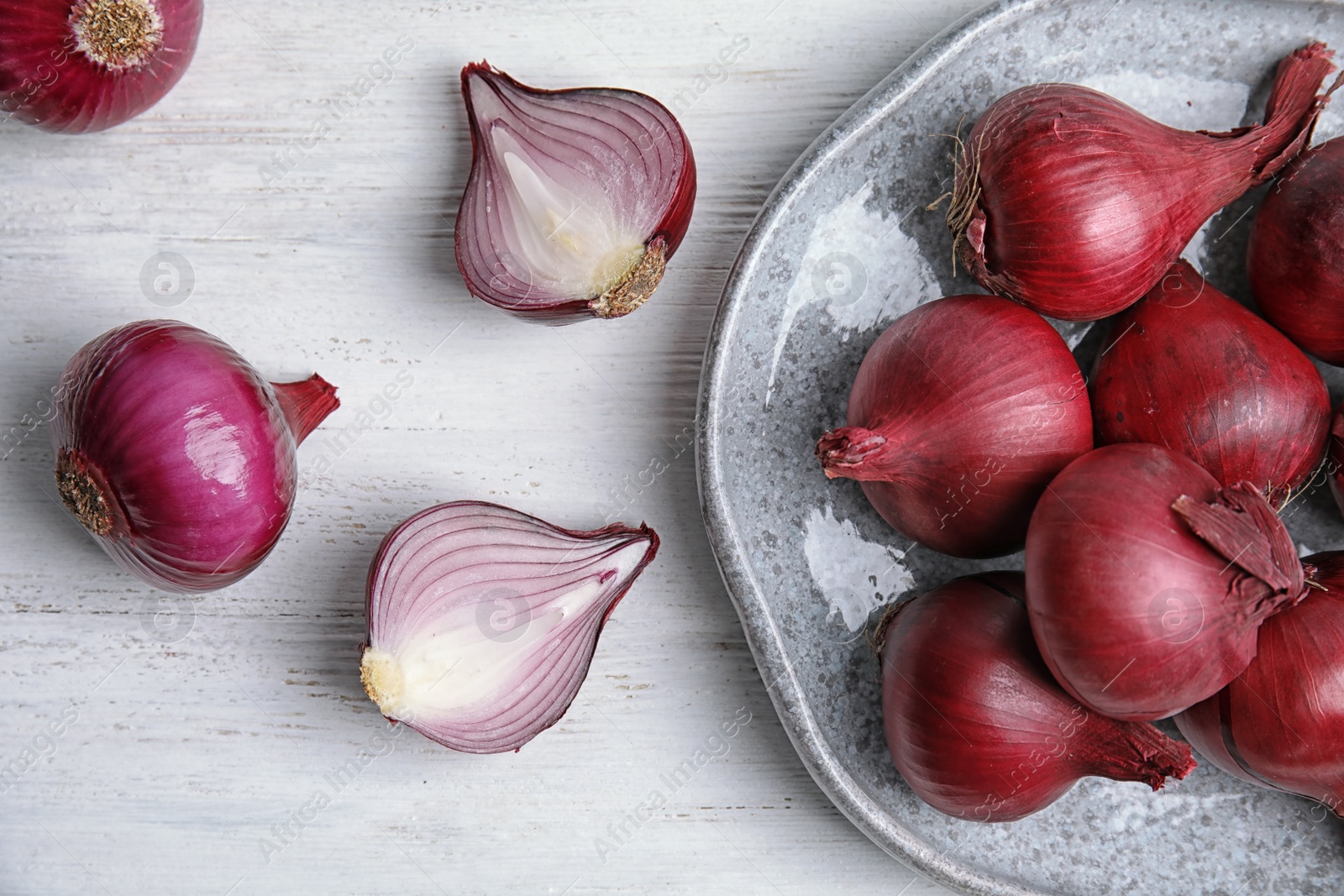 Photo of Plate with ripe red onions on table, top view