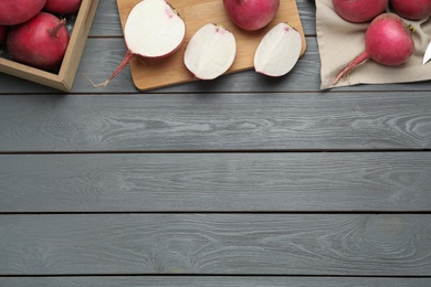 Photo of Raw red turnips on grey wooden table, flat lay. Space for text