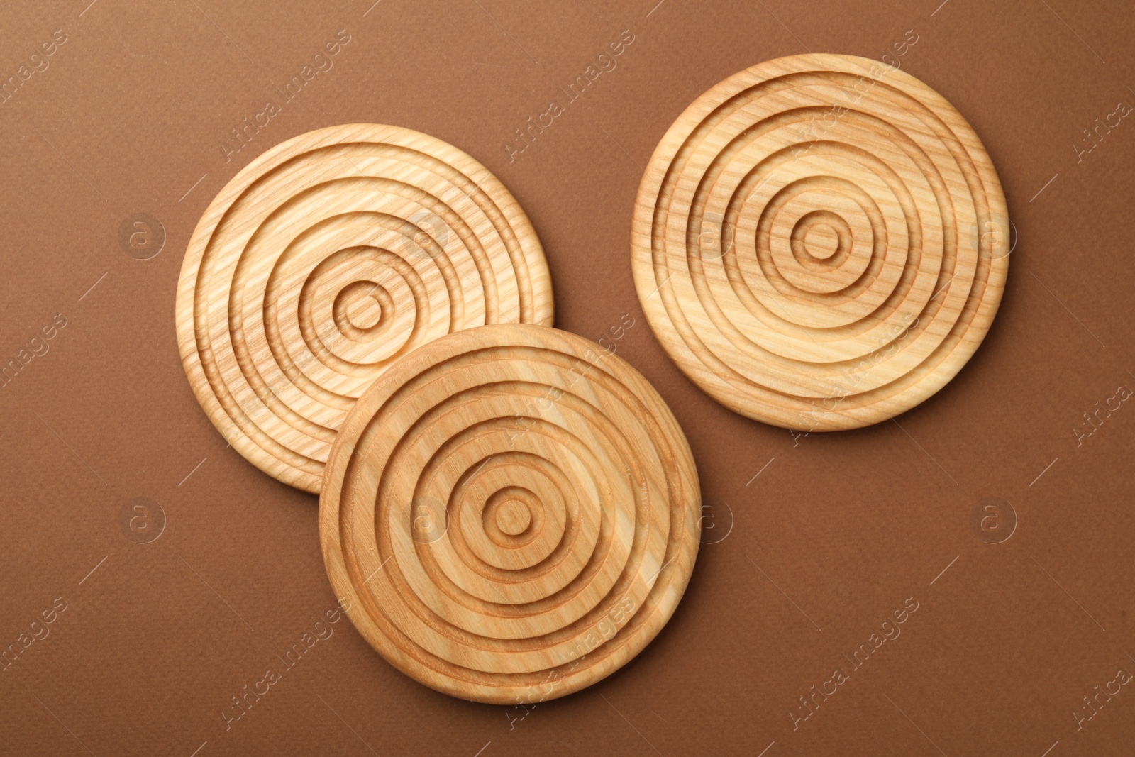 Photo of Stylish wooden cup coasters on brown background, flat lay