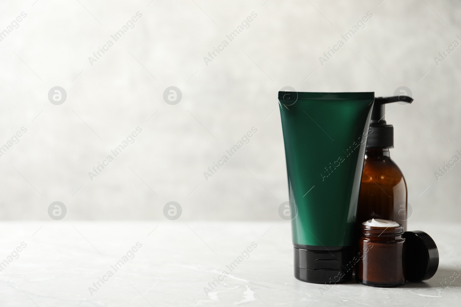 Photo of Facial cream and other men's cosmetic on light marble table. Mockup for design