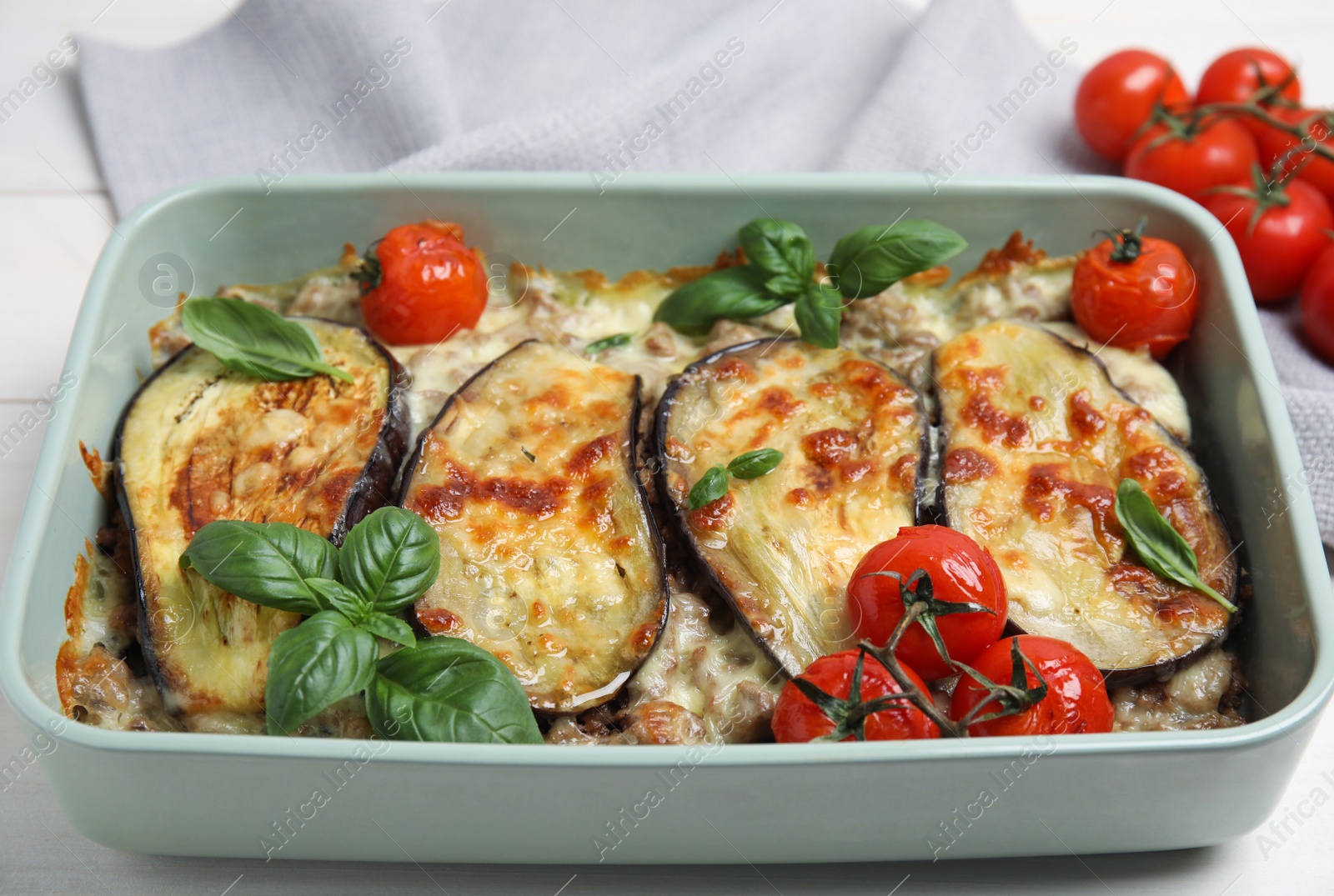 Photo of Delicious eggplant lasagna in baking dish on white wooden table