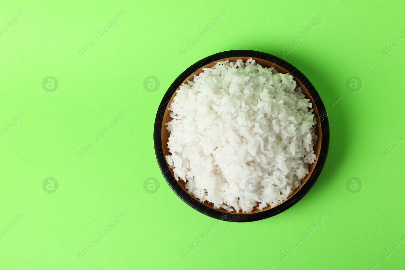 Photo of Bowl of boiled rice on color background, top view with space for text