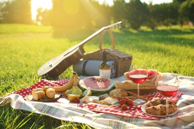 Picnic blanket with delicious food and drinks outdoors on sunny day