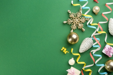Photo of Flat lay composition with serpentine streamers and Christmas decor on green background. Space for text