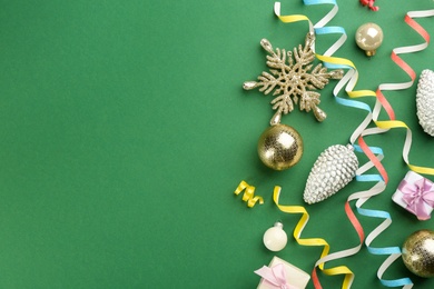 Flat lay composition with serpentine streamers and Christmas decor on green background. Space for text