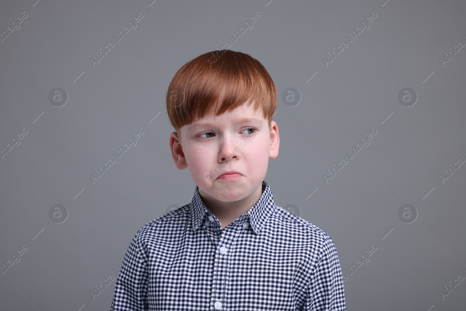 Photo of Portrait of sad little boy on grey background